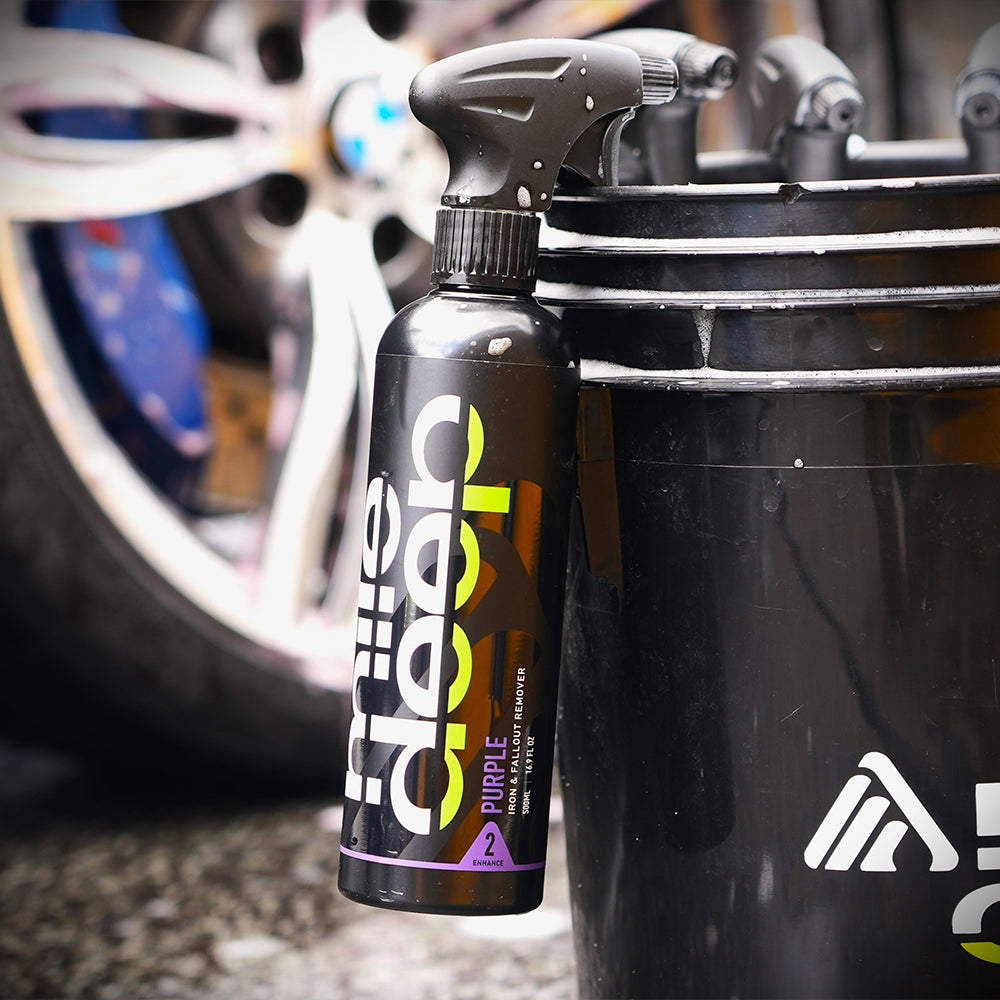 purple iron & fallout remover attached to bucket for cars